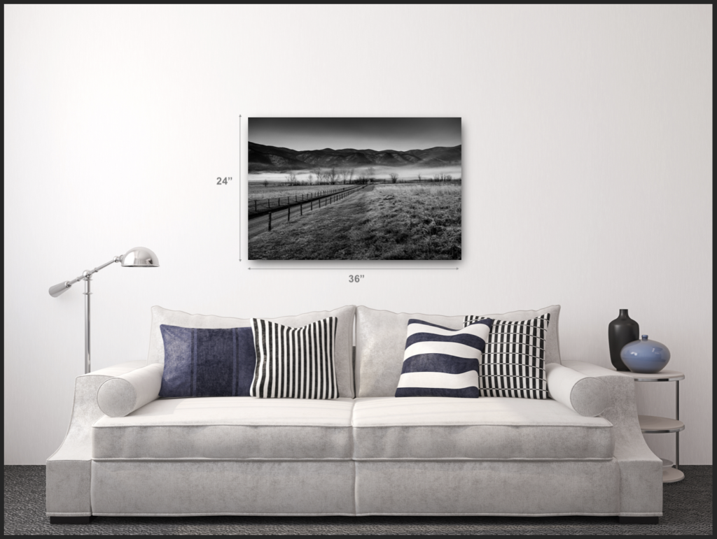 A modern style room complemented with a black and white metal print over a white couch with black and white striped pillows